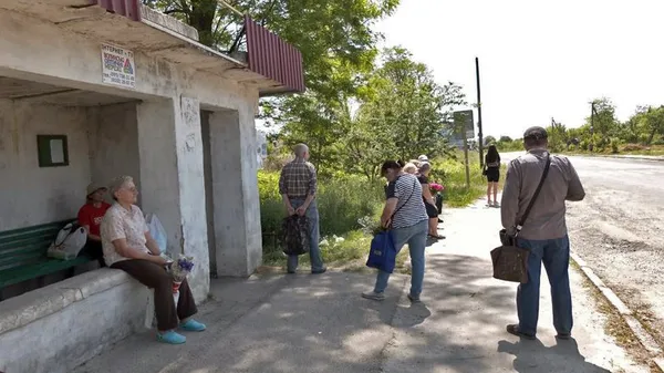 Люди чекають на автобус, аби дістатися з дач до Луцька, та займають чергу