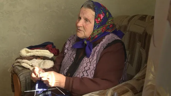 Волинянка в'яже теплі шкарпетки і передає солдатам на передову