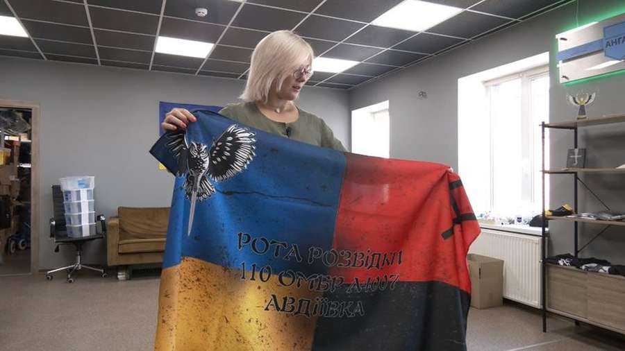 Юлія Савчук показує прапор роти розвідників 110-ої бригади з Авдіївки><span class=
