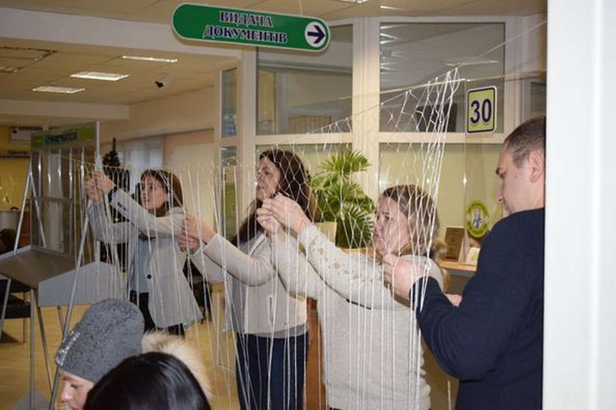 Поки очікують в черзі: у Луцькому ЦНАПі відвідувачі плетуть маскувальні сітки (фото)