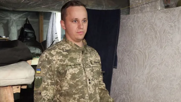 Боєць Микола показує облаштовану у бліндажі грубку.