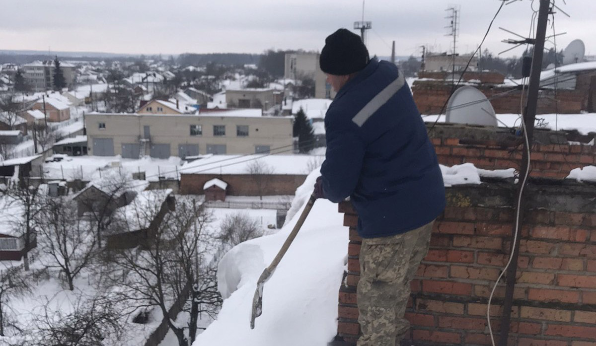 Без страховки: волинський комунальник заліз на небезпечний дах, щоб прибрати сніг (фото)